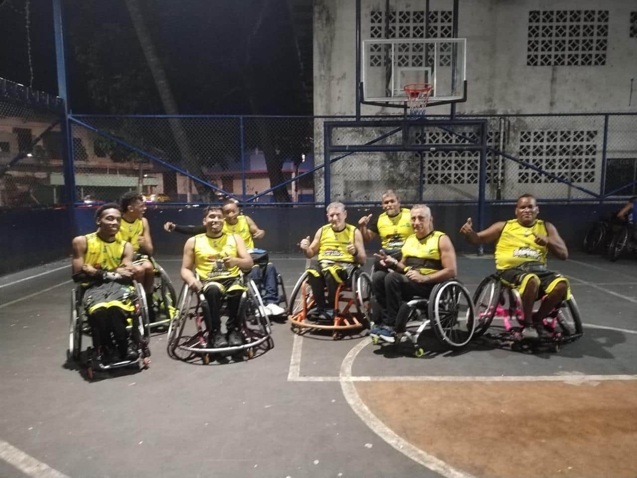 Los jugadores de baloncesto sobre ruedas, en fila, sobre la cancha al aire libre