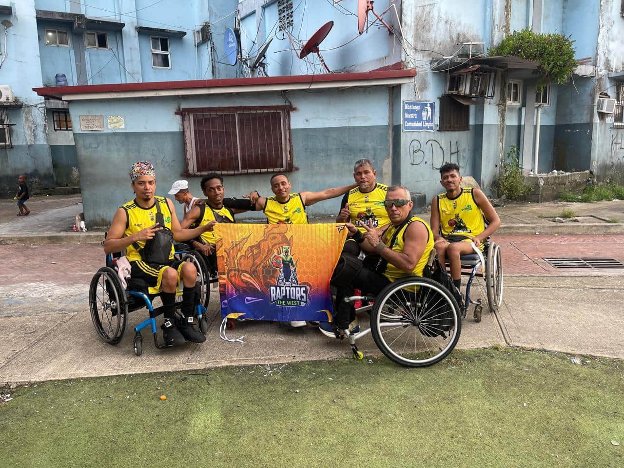 El equipo de baloncesto sobre ruedas posa en la cancha detrás de su pancarta